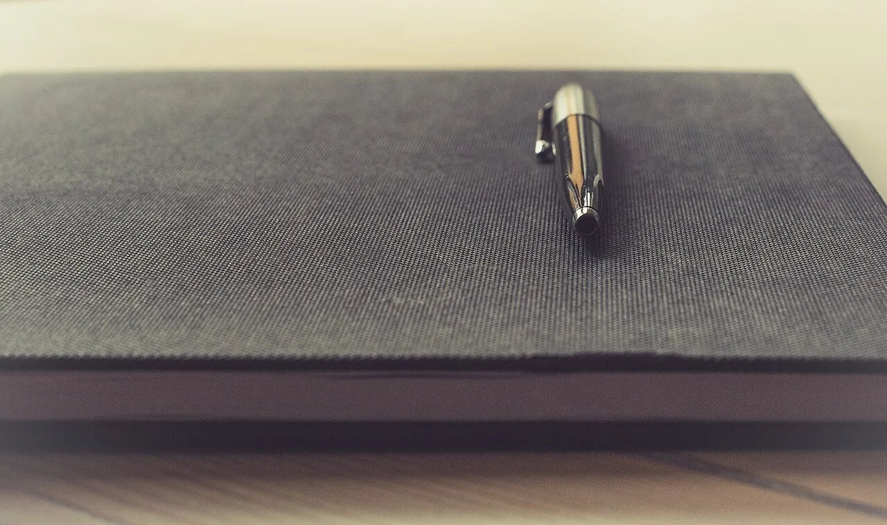 Pen on a notebook (Unsplash)